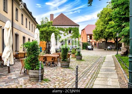 Idyllische Straße mit Restaurant, Fachwerkhaus und mit Efeu-Grünhaus in der Altstadt von Bernau bei Berlin, Deutschland Stockfoto