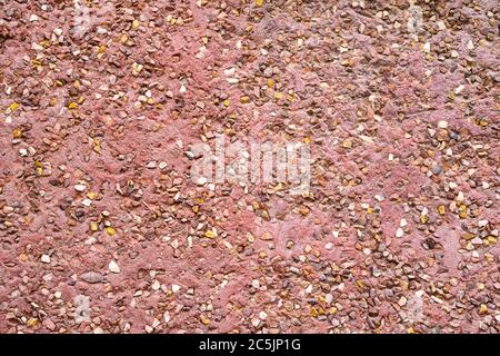 Textur Wandbeschichtung von Steinen. Hauswand Außenputz. Abstrakter Hintergrund Pflaster bestehend aus kleinen Kieselsteinen in Zement eingebettet Stockfoto