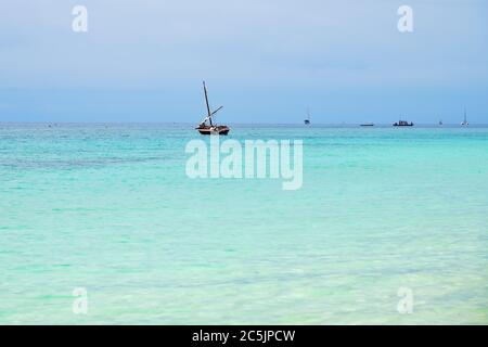 Dhow Segelboot im Indischen Ozean bei Sonnenaufgang, Sansibar, Tansania, Afrika Stockfoto