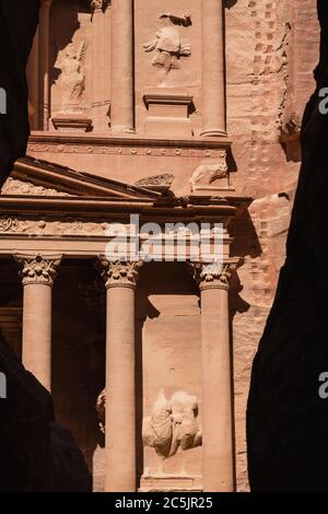 Jordanien, Petra, der erste Blick auf die Ruinen von Al Khazneh oder die Schatzkammer in der engen Schlitz Schlucht genannt Siq, die zu den Ruinen der Nabataean Stadt Petra im Petra Archeological Park führt ist ein jordanischer Nationalpark und ein UNESCO-Weltkulturerbe. Stockfoto