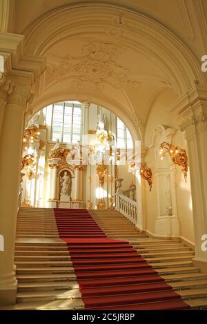 Wunderschön dekorierte Innenausstattung mit Gold- und rotem Teppich. Unterer Teil der Jordan Treppe, Winterpalast, Staatliche Eremitage Museum, St. Petersburg, Russland. Stockfoto