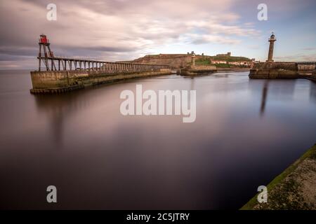 Abenddämmerung am Whitby Hafen vom Ende des Piers. Lange Exposition und ruhiges Wasser. Yorkshire Dales Touristenziel Stockfoto