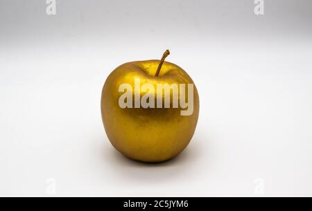 Ein goldener Apfel auf weißem Hintergrund Stockfoto