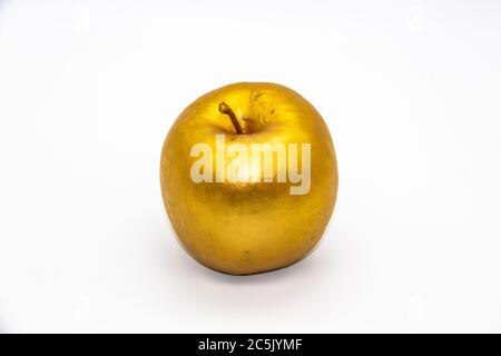 Ein goldener Apfel auf weißem Hintergrund Stockfoto