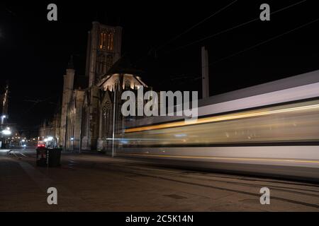 Gent, Belgien, 03/01/2020. Tramwege auf der Straße von Gent und monumentale Säulen Architektur im Hintergrund, lange Belichtung, verschwommene Bewegung, Stadt Stockfoto