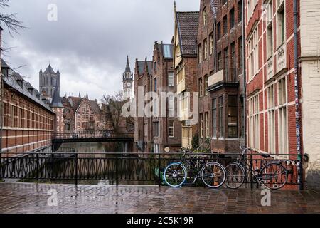 Gent, Belgien, 03/02/2020. Im Hintergrund der Uhrturm des alten Postamts und der Kathedrale von St. Bavo (Sint-Baafskathedral). Zwei Fahrräder auf Th Stockfoto