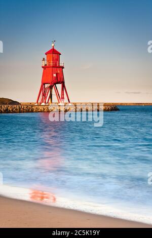 Blick entlang der Felspier in Richtung des roten Leuchtturms in South Shields an einem frühen Sommerabend Stockfoto