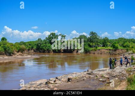 Touristen und Park Ranger Blick auf Nilpferde in der Mara River, Mara Dreieck, Masai Mara National Reserve, Kenia, Ostafrika Stockfoto