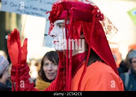 Globaler Klimaangriff auf dem St. Peter's Square, Manchester, Großbritannien. Auslöschung Rebellion unsichtbare Zirkus roten Rebellen. Mann im Profil mit der Hand hochgehalten Stockfoto