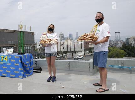 Williamsburg, Usa. Juli 2020. Weltmeister Joey Chestnut, der #1-rangige Esser der Welt, Und die Meisterin Miki Sudo trägt eine schützende Gesichtsmaske, wenn sie auf einem Dach mit Blick auf die Williamsburg Bridge steht, nachdem sie offiziell für den 104. Nathan's Famous Fourth of July International Hot Dog Eating Contest am 3. Juli 2020 in New York City eingewogen und zertifiziert wurde. Der berühmte internationale Hot Dog Eating Contest von Nathan am 4. Juli findet seit 1916 jedes Mal am 4. Juli auf Coney Island statt. Foto von John Angelillo/UPI Kredit: UPI/Alamy Live Nachrichten Stockfoto