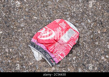 Zerschlagen und zerknittert leere Coca-Cola-Dose auf dem Boden in der Straße gelegt achtlos verschmutzen die Umwelt Stockfoto