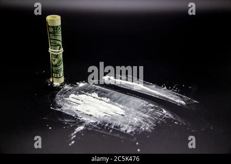 Der gefährliche Kokain mit einem Dollar. Heldin auf schwarzem Hintergrund. Stockfoto