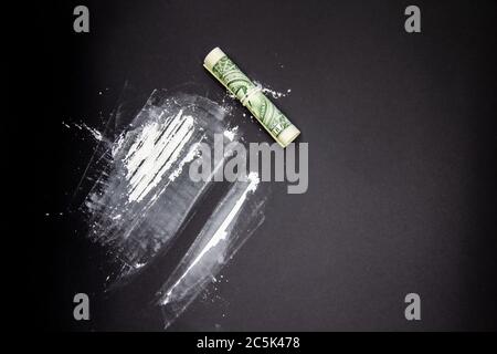 Der gefährliche Kokain mit einem Dollar. Heldin auf schwarzem Hintergrund. Stockfoto