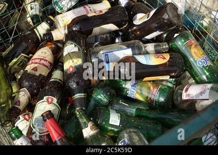 Glasflaschen aus Bier und Limonade in einem Mülleimer. Nahaufnahme. Mülltrennung und Recycling Konzept. August 2018, Odessa, Ukraine Stockfoto