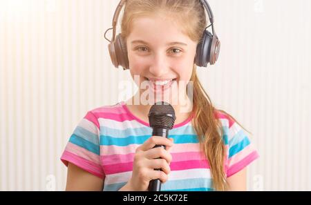 Mädchen in Kopfhörern singen im Studio Stockfoto