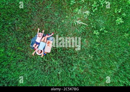 Zwei kleine Mädchen auf einem grünen Gras, Luftaufnahme von oben Stockfoto