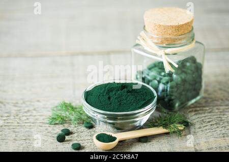 Spirulina Tabletten und Pulver in Schalen Stockfoto