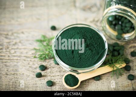 Spirulina Tabletten und Pulver in Schalen Stockfoto