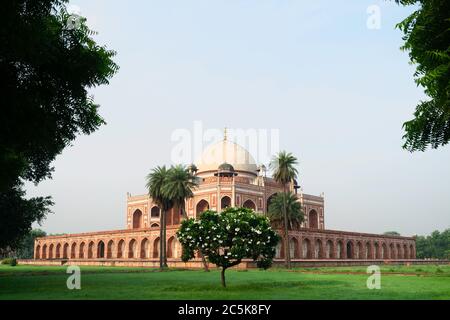 Das historische Humayun-Grab wurde von einem Aussichtspunkt aus in Gärten betrachtet, die im Sommer im Morgengrauen in Delhi, Indien, von Bäumen umgeben waren. Stockfoto