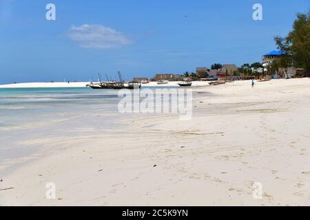 Kendwa, Sansibar - 4. Oktober 2019: Das Ufer des Indischen Ozeans, weißer Sandstrand bei Ebbe, Fischerboote im Hintergrund, Tansania, Afrika Stockfoto