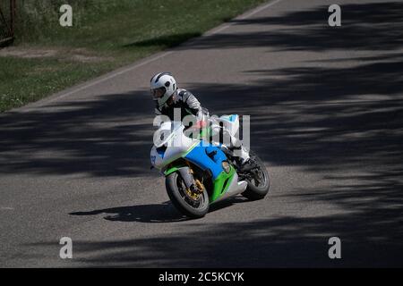 Mann Motorrad fahren in Asphalt Straßenkurve mit ländlichen, Motorrad-Praxis lehnt in eine schnelle Ecke auf der Strecke Stockfoto