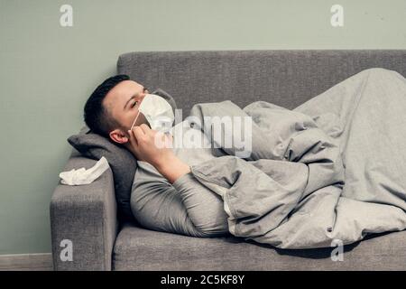Krankheit. Zu Hause erfreuen. Ein junger Mann ist krank, ist zu Hause behandelt. Bläst ihre Nase in eine Serviette, laufende Nase. Infektion, Epidemie, Bacillus Träger. Stockfoto