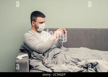 Krankheit. Zu Hause erfreuen. Ein junger Mann ist krank, ist zu Hause behandelt. Bläst ihre Nase in eine Serviette, laufende Nase. Infektion, Epidemie, Bacillus Träger. Stockfoto