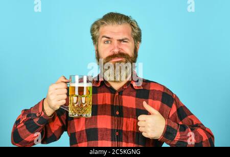 lagerbier. Entspannter, gutaussehender Mann, der leckeres Bier trinkt. Glas im Pub genießen. Frisches, kaltes Lagerbier vorwegnehmen. Nach einem anstrengenden Arbeitstag. Bier vom Fass an der Bar im Pub trinken. Stockfoto