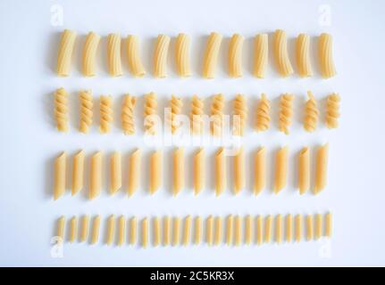 Verschiedene Arten von rohen Nudeln auf weißem Hintergrund, vegetarische Lebensmittel knolling Konzept. Stockfoto