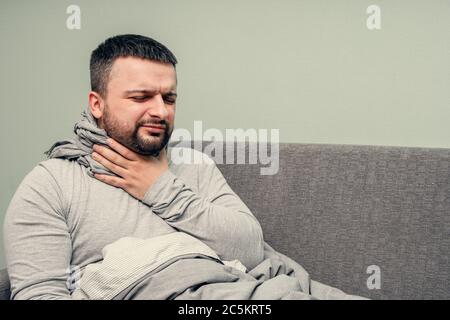 Krankheit. Zu Hause erfreuen. Ein junger Mann ist krank, ist zu Hause behandelt. Bläst ihre Nase in eine Serviette, laufende Nase. Infektion, Epidemie, Bacillus Träger. Stockfoto