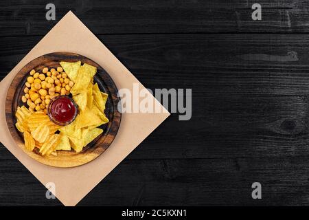 Große Auswahl an Snacks für Bier mit verschiedenen Saucen auf Pergament Draufsicht Stockfoto