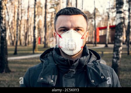 Ein Mann in einer Schutzmaske in einem leeren Park. Quarantäne und Selbstisolierung. Coronavirus-Pandemie. Stockfoto