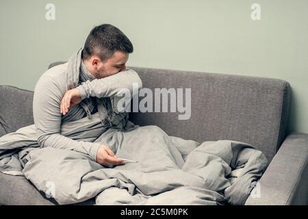 Krankheit. Zu Hause erfreuen. Ein junger Mann ist krank, ist zu Hause behandelt. Bläst ihre Nase in eine Serviette, laufende Nase. Infektion, Epidemie, Bacillus Träger. Stockfoto