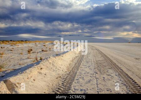 Reifenspuren auf einer abgelegenen Schotterstraße durch die Wüste des White Sands National Monument in Alamogordo, New Mexico. Stockfoto