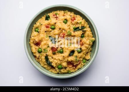 Gemüse Dalia oder Daliya Khichadi oder gebrochene Weizen Khichdi mit Tomaten, grünen Erbsen und Chili, in einer Schüssel oder einem Teller serviert Stockfoto