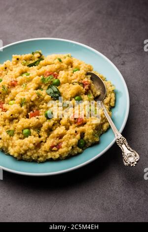 Gemüse Dalia oder Daliya Khichadi oder gebrochene Weizen Khichdi mit Tomaten, grünen Erbsen und Chili, in einer Schüssel oder einem Teller serviert Stockfoto