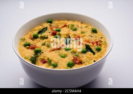 Gemüse Dalia oder Daliya Khichadi oder gebrochene Weizen Khichdi mit Tomaten, grünen Erbsen und Chili, in einer Schüssel oder einem Teller serviert Stockfoto