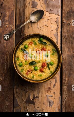 Gemüse Dalia oder Daliya Khichadi oder gebrochene Weizen Khichdi mit Tomaten, grünen Erbsen und Chili, in einer Schüssel oder einem Teller serviert Stockfoto