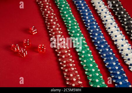 Stapel von Poker-Chips auf rotem Hintergrund im Casino Stockfoto