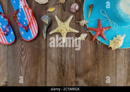 Reiseurlaub während mit Muscheln, Seesterne, auf Flip Flops die gegen Ruhe am Strand Hut entspannend Stockfoto