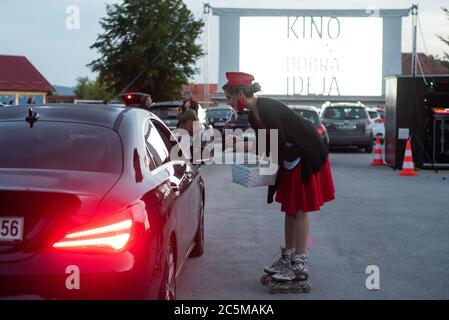 Ptuj, Slowenien. Juli 2020. Eine Kellnerin nimmt vor der Vorführung eines Films 'Grease' mit John Travolta und Olivia Newton-John auf einem temporären Drive-in-Kinoparkplatz eine Bestellung auf.aufgrund der Ausbreitung des Coronavirus (COVID-19) organisierte das City Cinema eine Outdoor-Vorführung. Kredit: SOPA Images Limited/Alamy Live Nachrichten Stockfoto