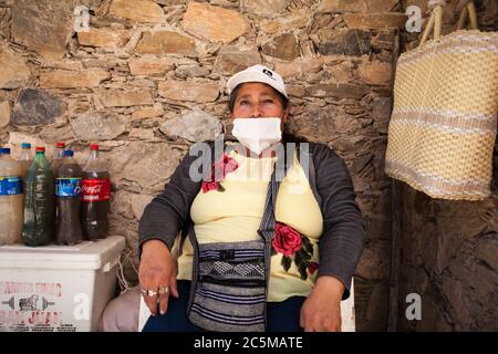 Real De Catorce, Mexiko. Juni 2020. Eine Frau mit Gesichtsmaske verkauft ''˜aguamiel', ein vorhispanischer traditioneller Drink, der aus dem Herzen der Agavenpflanze stammt.die ''˜neue Normalität' in Mexiko begann Anfang Juni mit dem Ende der Sperre. Die ersten Plätze zu öffnen waren Tourismus, die Städte mit Null Coronavirus Fällen, wie Real de Catorce, San Luis PotosÃ-. Obwohl die Zahl der Besucher nicht mit der vor der Covid-19-Pandemie vergleichbar ist, hat sie langsam begonnen, die Wirtschaft zu aktivieren, insbesondere dort, wo der Tourismus die Haupteinnahmequelle ist. (Bild: © Antoni Stockfoto