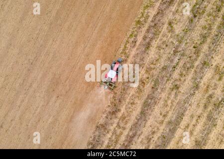 Luftdrohnenansicht eines Traktors, der auf einem Feld pflügt Stockfoto