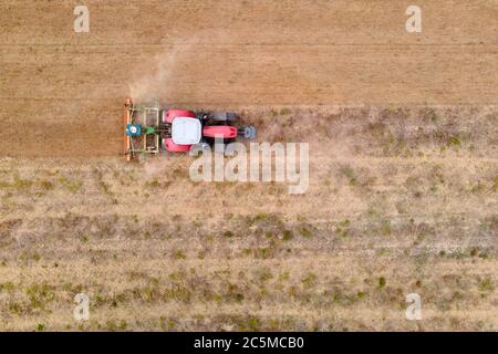Luftdrohnenansicht eines Traktors, der auf einem Feld pflügt Stockfoto