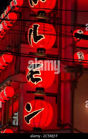 Osaka / Japan - 19. März 2018: Leuchtend rote Laternen, die ein Izakaya Restaurant und eine Bar im Dotonbori Viertel im Zentrum von Osaka anwerben. Ein Izakaya ist ein Typ Stockfoto