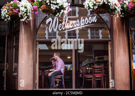 Einer der ersten Trinker bei der Wiedereröffnung des Rochester Castle Pub in Stoke Newington, North London, als Coronavirus-Sperrbeschränkungen in ganz England gelockert werden. Stockfoto