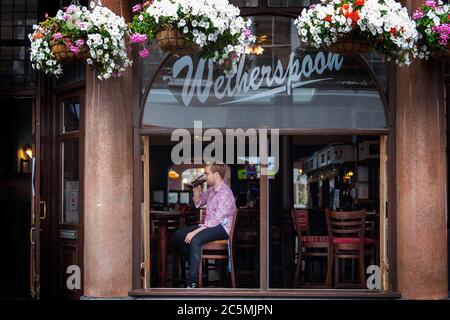 Einer der ersten Trinker bei der Wiedereröffnung des Rochester Castle Pub in Stoke Newington, North London, als Coronavirus-Sperrbeschränkungen in ganz England gelockert werden. Stockfoto