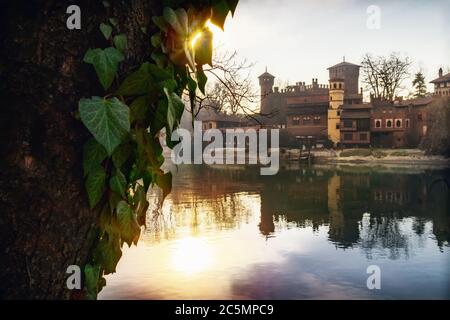 Turin (Piemont, Italien), der Fluss Po und der berühmte Borgo Medievale, neogotische Burg im Valentino öffentlichen Park bei Sonnenuntergang Stockfoto