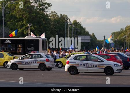 Bukarest, Rumänien - Juni 24 2018: Polizeiautos parkten vor einer Menschenmenge, die den 100. Jahrestag des Großraums Rumänien feiert. Stockfoto