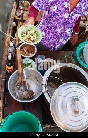 Bootnudeln, thailändischer Verkäufer, der Reisnudeln auf dem Boot verkauft, getrocknete Reisnudeln mit geschnittenem Schweinefleisch und Fleischbällchen, traditionelle thailändische Nudeln. Stockfoto